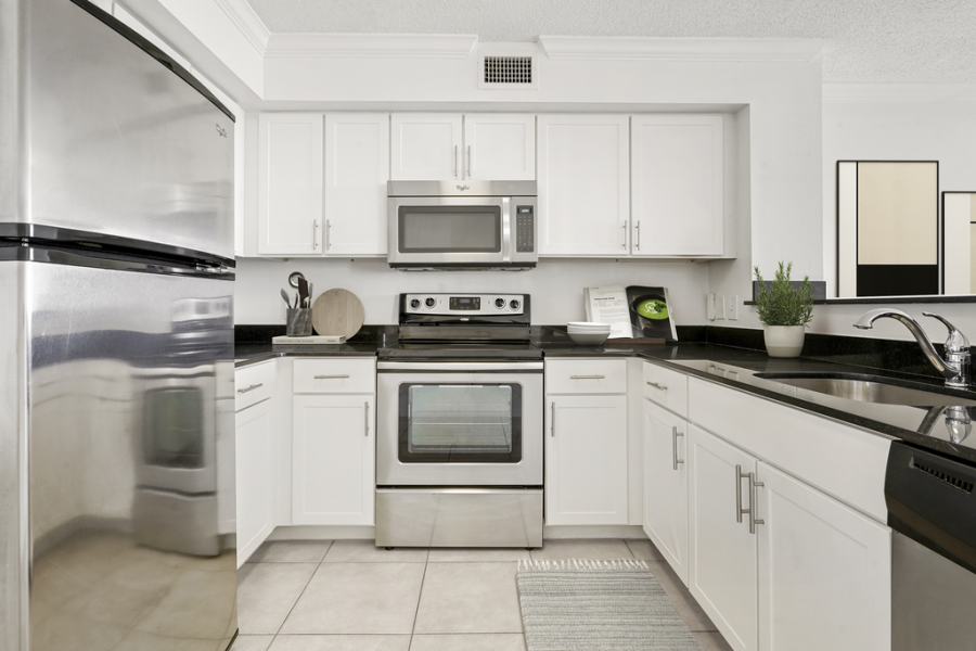 Built in microwave, glass top stove, goose neck faucet, pantry, white quartz countertops, stainless steel appliances